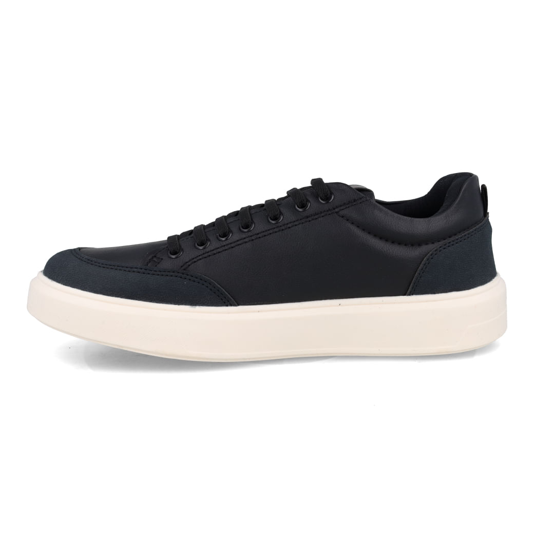 Tênis casual masculino preto com solado branco visto de lado em fundo branco